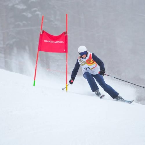 Skieuse qui passe à gauche d'une porte de slalom